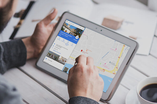 A man looking at a tablet showing Google Maps with a Google Business Fade-in